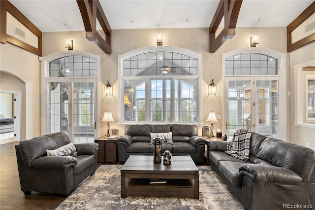 living room with hardwood / wood-style flooring, beamed ceiling, and french doors