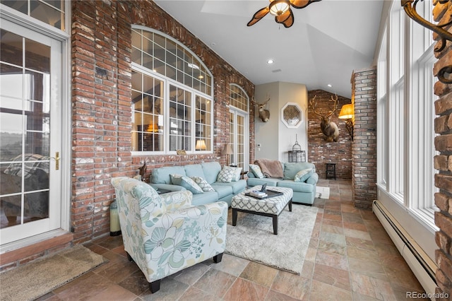 living room featuring ceiling fan, a baseboard radiator, brick wall, lofted ceiling, and a fireplace