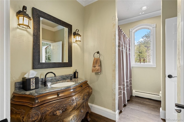 bathroom with vanity, a baseboard heating unit, crown molding, and hardwood / wood-style flooring