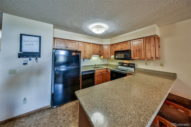 56 Gcr 834 Unit 2F, Fraser, CO 80442 - kitchen with black appliances, a peninsula, brown cabinets, a kitchen bar, and tile patterned flooring