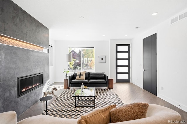 living room featuring a large fireplace and light hardwood / wood-style floors