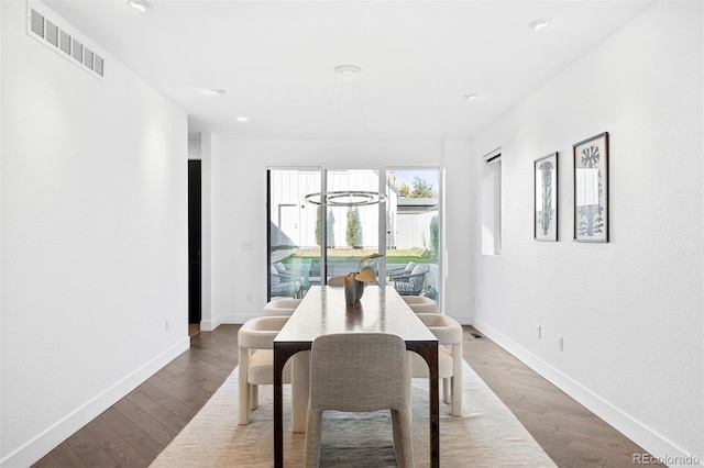 dining room with dark hardwood / wood-style flooring and a chandelier