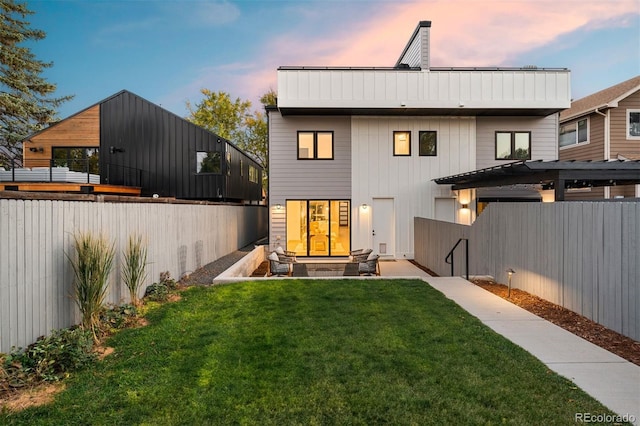 back house at dusk featuring a yard