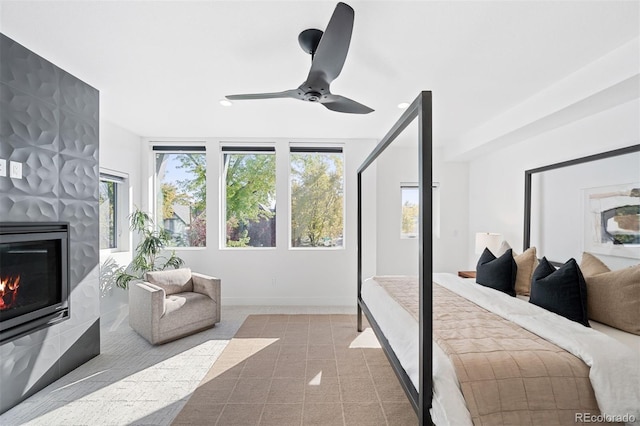 bedroom featuring a fireplace and ceiling fan