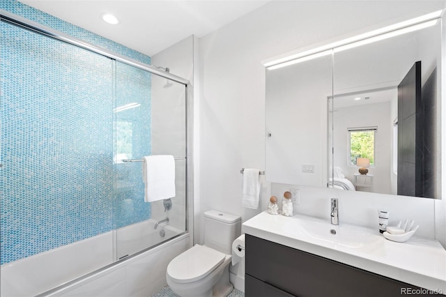 full bathroom with vanity, toilet, and bath / shower combo with glass door