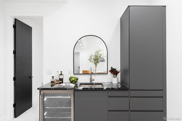 bar featuring beverage cooler, gray cabinetry, and sink