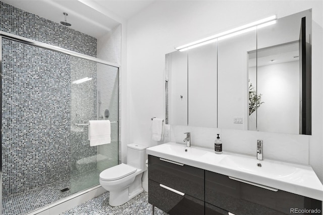 bathroom featuring tile patterned floors, vanity, toilet, and walk in shower