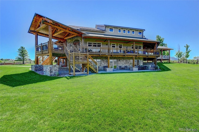 rear view of house with a patio, a deck, and a lawn