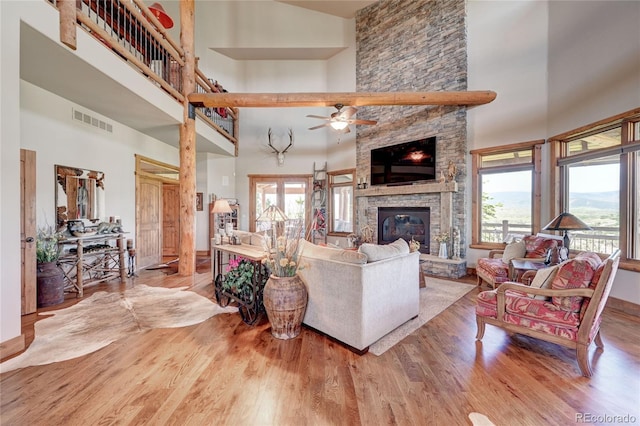 living room with a high ceiling, plenty of natural light, and a fireplace