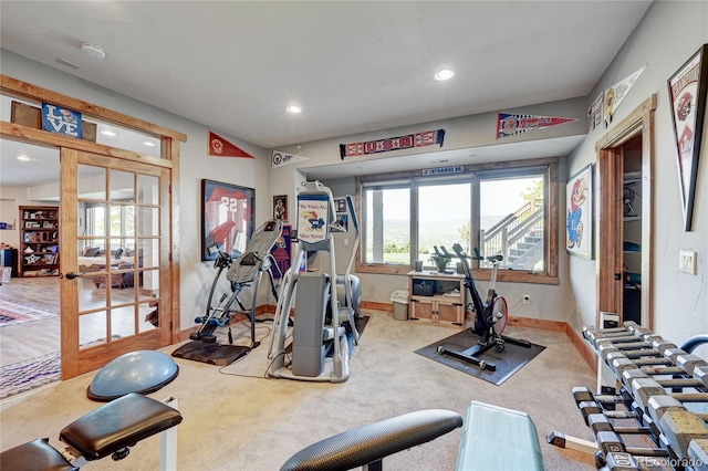 exercise area featuring french doors and carpet flooring