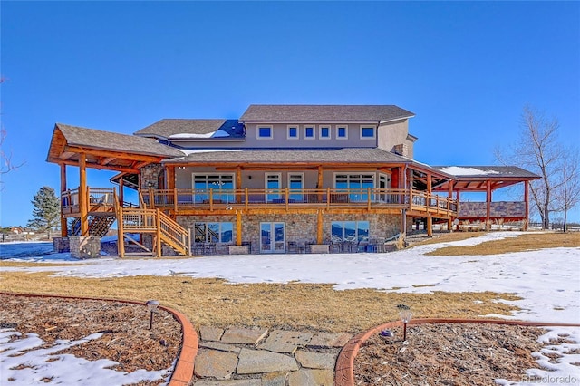 snow covered rear of property featuring a deck