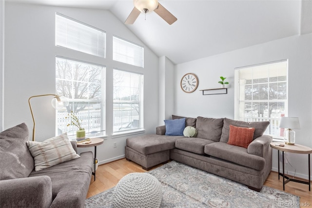 living room featuring high vaulted ceiling, light hardwood / wood-style floors, and ceiling fan