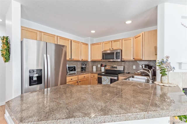 kitchen with sink, stainless steel appliances, kitchen peninsula, and light brown cabinets