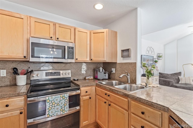 kitchen featuring stainless steel appliances, tasteful backsplash, sink, and light brown cabinets