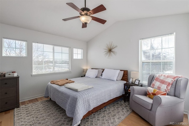 bedroom with ceiling fan, lofted ceiling, and light wood-type flooring