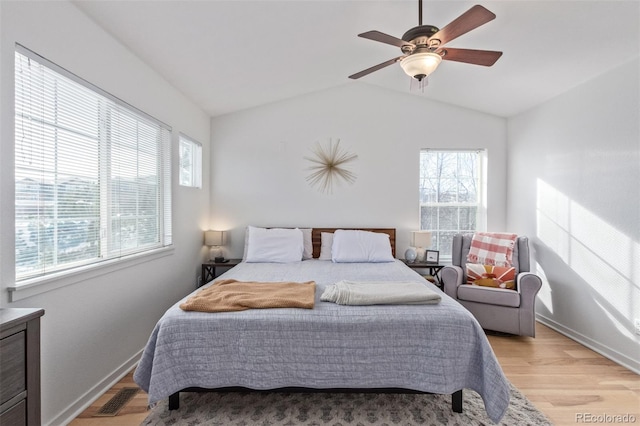 bedroom with ceiling fan, vaulted ceiling, and light wood-type flooring