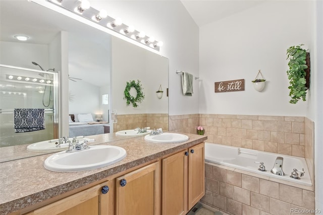 bathroom featuring lofted ceiling, vanity, and tiled tub