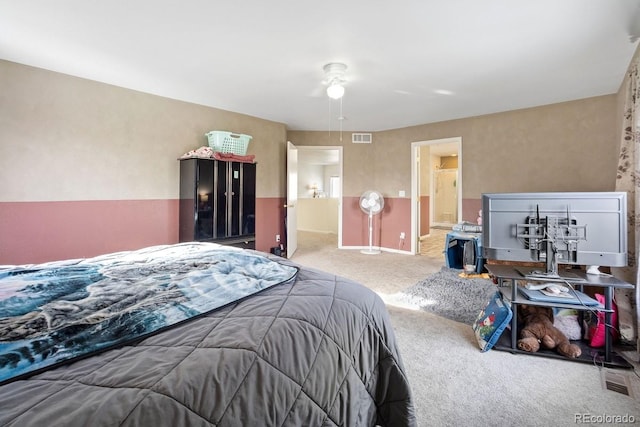 bedroom with carpet, ceiling fan, and connected bathroom