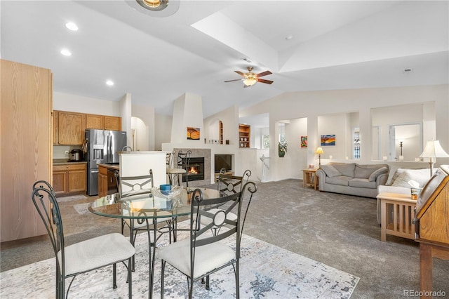 dining room featuring vaulted ceiling, light carpet, a glass covered fireplace, a ceiling fan, and recessed lighting