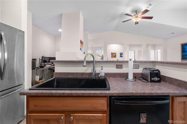 kitchen featuring freestanding refrigerator, dishwasher, a sink, dark countertops, and lofted ceiling