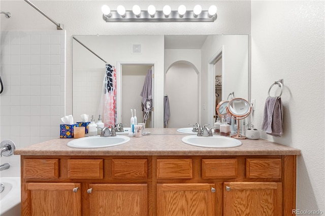 bathroom featuring double vanity and shower / bath combo