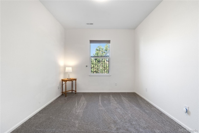 carpeted empty room featuring baseboards