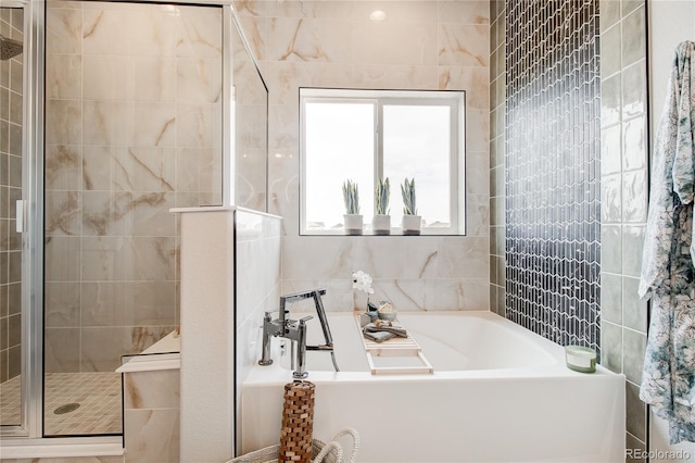 bathroom with tile walls and shower with separate bathtub