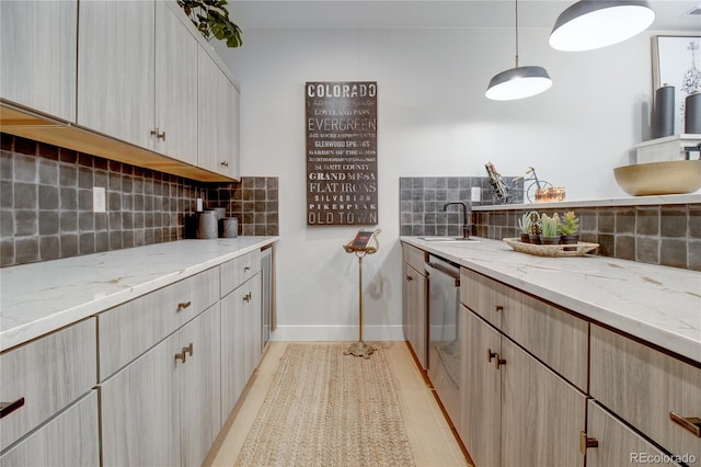 kitchen featuring backsplash, light stone counters, light brown cabinets, and light hardwood / wood-style flooring