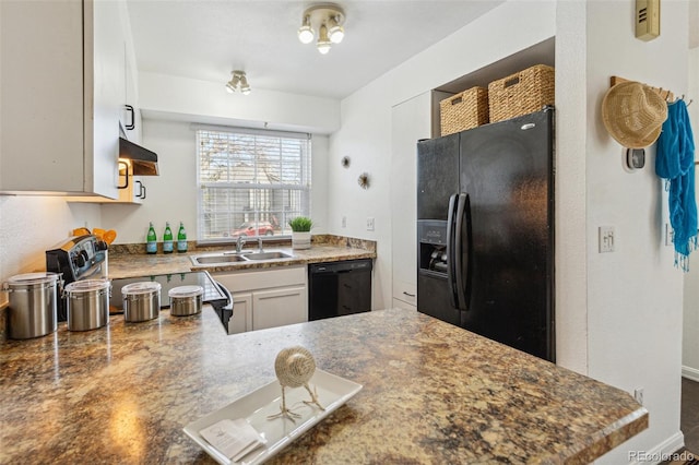 kitchen with sink, black appliances, kitchen peninsula, and white cabinets