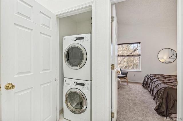 washroom featuring light carpet and stacked washer and dryer