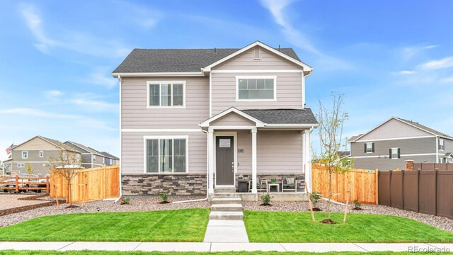 22323 E 6th Pl, Aurora, CO 80018 - craftsman-style house with a front lawn, fence, and stone siding