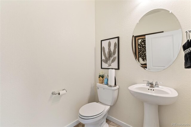 22323 E 6th Pl, Aurora, CO 80018 - bathroom featuring toilet, baseboards, and a sink