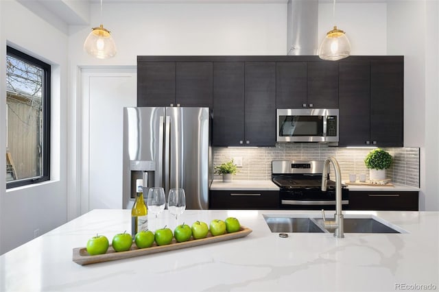 kitchen with decorative backsplash, sink, hanging light fixtures, and appliances with stainless steel finishes