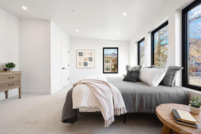 carpeted bedroom with vaulted ceiling and multiple windows