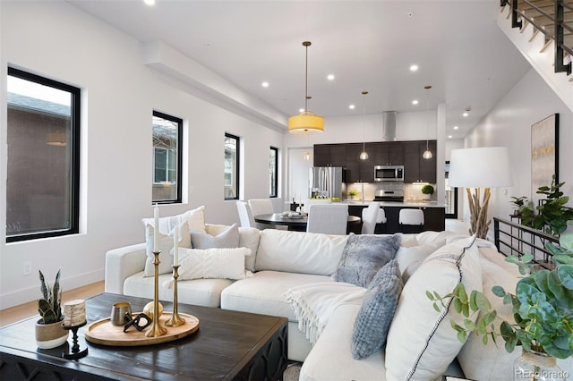 living room featuring baseboards, light wood-style floors, and recessed lighting