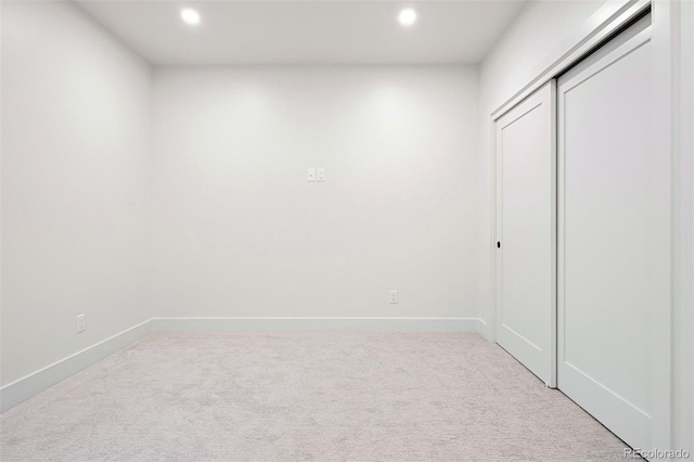 unfurnished bedroom featuring light carpet, baseboards, and recessed lighting