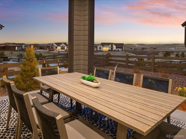 balcony at dusk featuring outdoor dining space