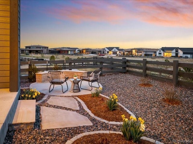patio terrace at dusk with fence and a residential view