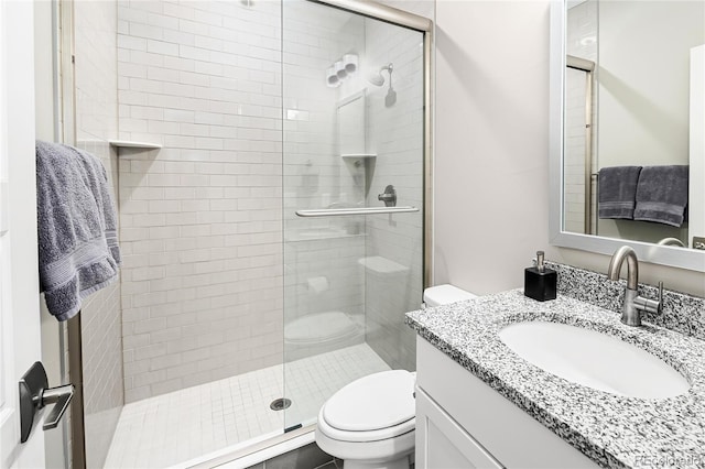 full bathroom featuring toilet, a shower stall, and vanity