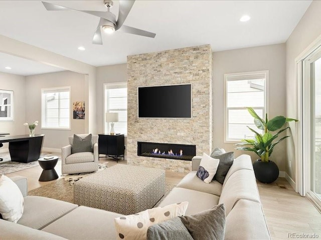 living room with baseboards, recessed lighting, a fireplace, a ceiling fan, and wood finished floors