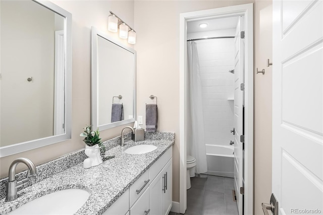 full bathroom featuring a sink, tile patterned floors, toilet, and double vanity
