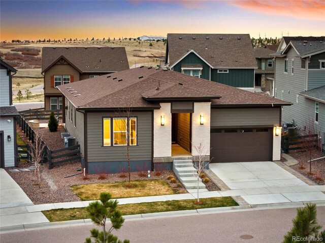 view of front of home featuring concrete driveway, a garage, fence, and roof with shingles