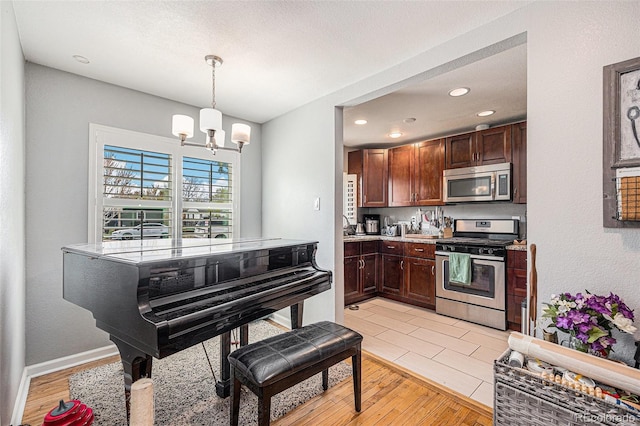3640 N Saint Paul St, Denver, CO 80205 - kitchen with stainless steel appliances, a chandelier, light wood-style flooring, pendant lighting, and recessed lighting