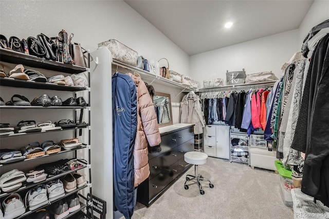walk in closet featuring carpet and lofted ceiling
