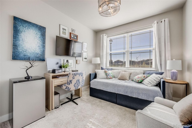 carpeted living area with baseboards and an inviting chandelier