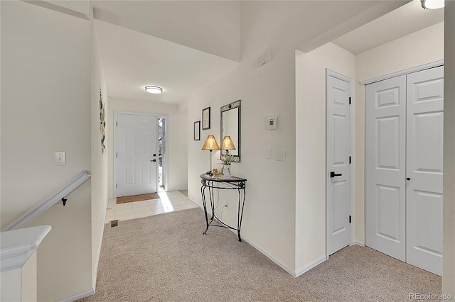 foyer with light colored carpet, visible vents, baseboards, and light tile patterned flooring