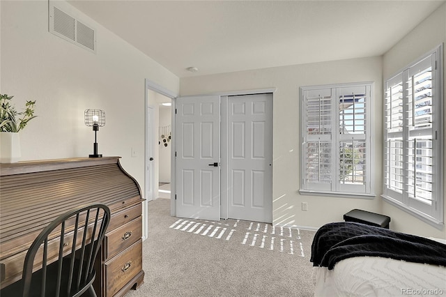 carpeted bedroom featuring multiple windows, visible vents, and baseboards