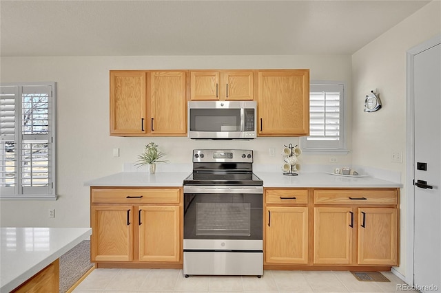 kitchen with appliances with stainless steel finishes, light countertops, and light brown cabinets