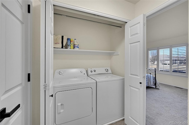 laundry room with laundry area, washer and dryer, and carpet flooring