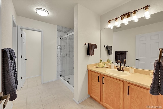 bathroom with a stall shower, tile patterned flooring, vanity, and baseboards